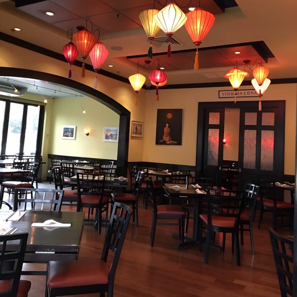 Dining room at Vietnam Philadelphia with red and orange lanterns, dark tables, and chairs.