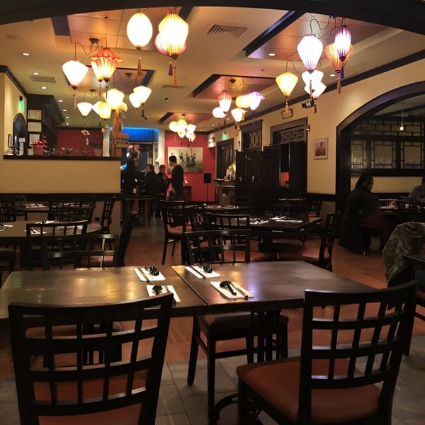 The dining room of Vietnam Philadelphia, featuring many tables, chairs, and decorative lanterns.